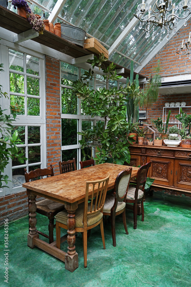 Naklejka premium Interior dining design and decoration of coffee cafe, bakery shop and fusion restaurant decorated with wooden furniture, flower plants and sculpture