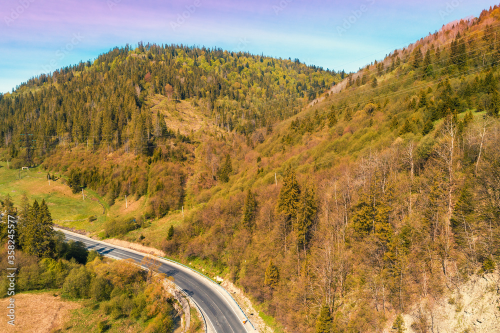 Panoramic aerial view of the mountains with highway. Beautiful mountain spring landscape. Carpathian mountains. Ukraine