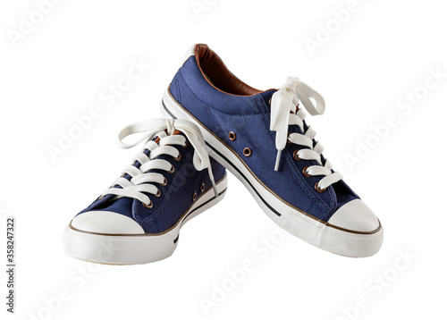 Pair of classic blue sneakers or gumshoes with white shoe laces isolated on white background. Comfortable shoes for fitness and sport.