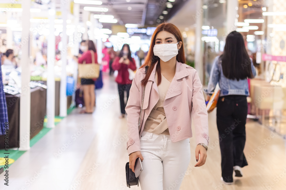 asian beautiful woman wearing medical mask for prevent dust and infection virus, female walking in department stores. asian beautiful woman wearing medical mask for prevent dust and infection virus, female walking in department stores.