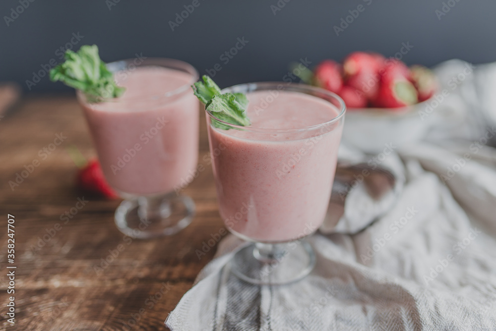 Fresh strawberry smoothie with mint on a linen rag on a wooden background. Fresh strawberry smoothie with mint on a linen rag on a wooden background.