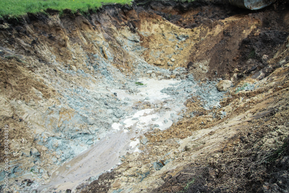 Dug hole in the ground is filled with water to the level. Swamp from the element that destroyed human activity. Stock abstract background