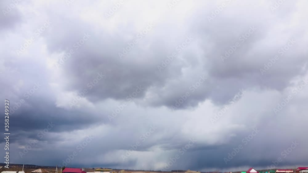 Timelapse of a stormy sky and rain fall in the background of a small village Timelapse of a stormy sky and rain fall in the background of a small village
