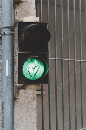 A heart on a green traffic light in a city scape