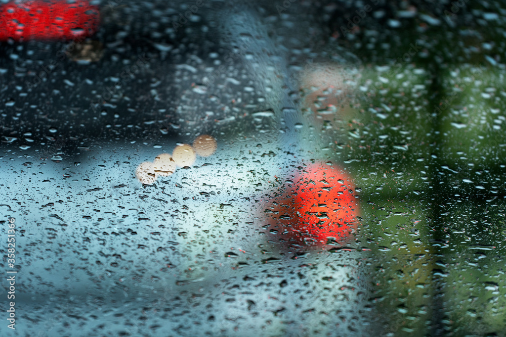 rain drop on glass window with blur car city traffic in bad whether background