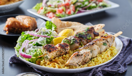 greek chicken souvlaki platter with pita bread, salad and rice
