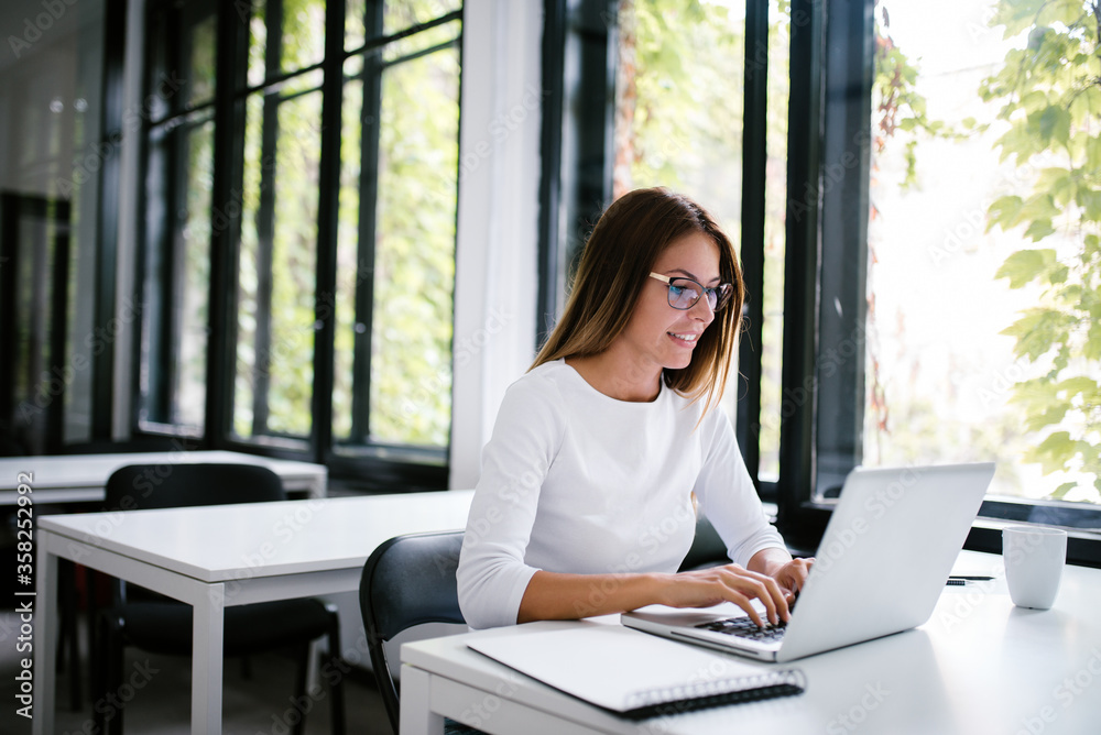 Young casual woman working on laptop computer. Young casual woman working on laptop computer.