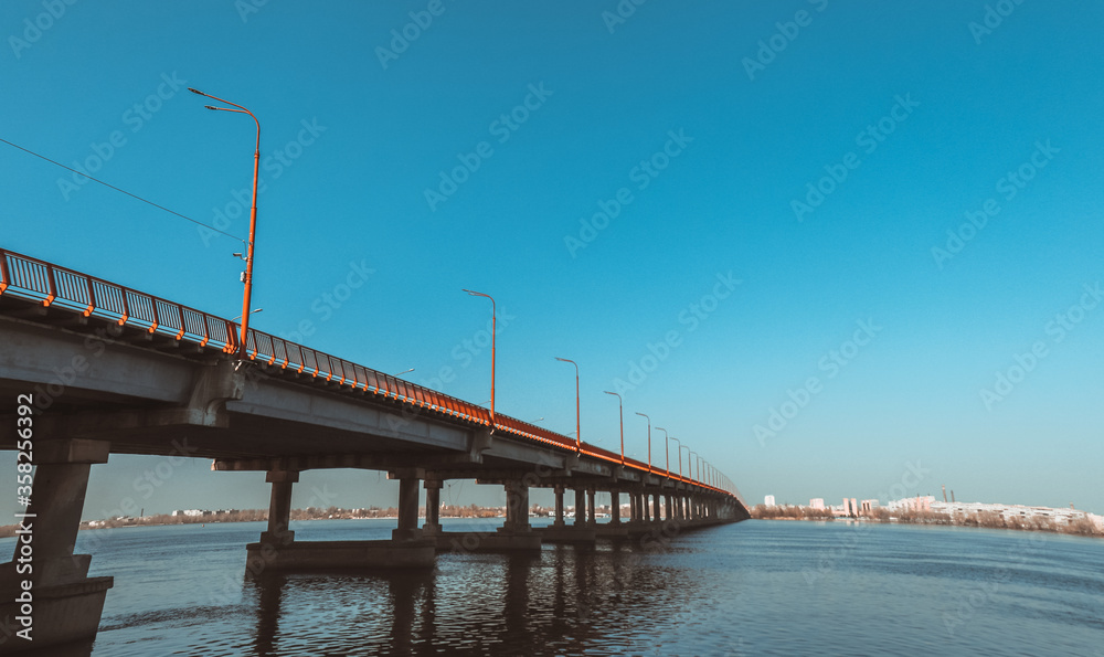 Long bridge over the river on a sunny summer day. Long bridge over the river on a sunny summer day.