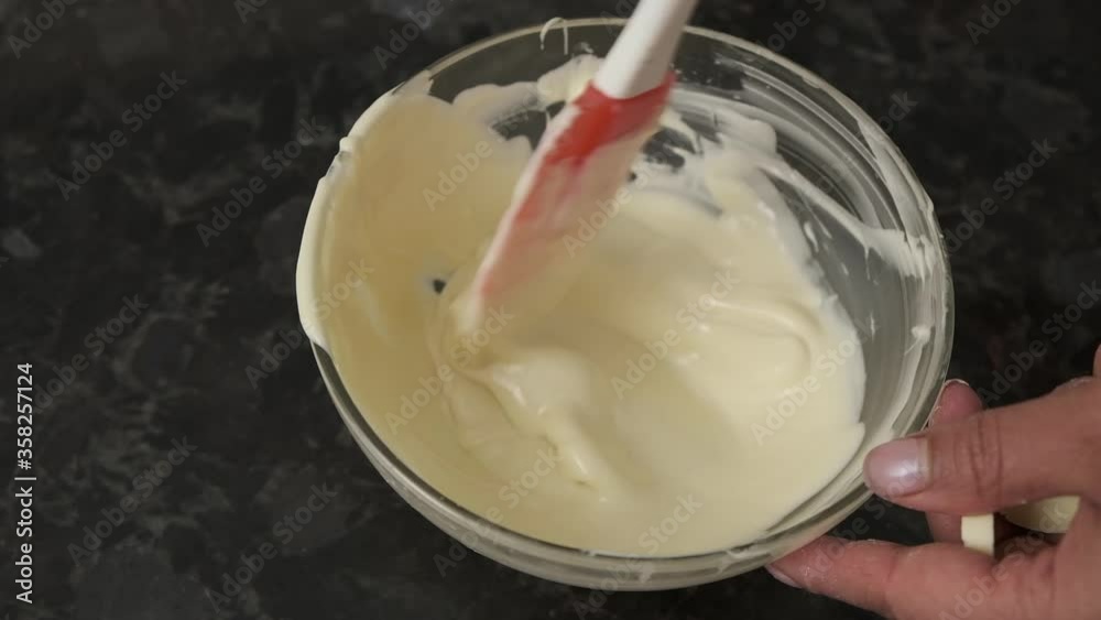 Dipping white chocolate in a cream. Dipping white chocolate in a cream.
