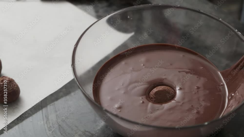 Truffle candy falling in a bowl with chocolate cream. Truffle candy falling in a bowl with chocolate cream.