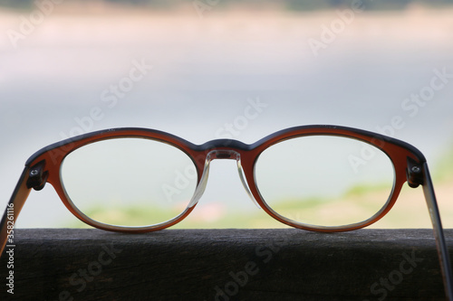Fototapeta Naklejka Na Ścianę i Meble -  Eye glasses on wooden floor, natural background, out door.