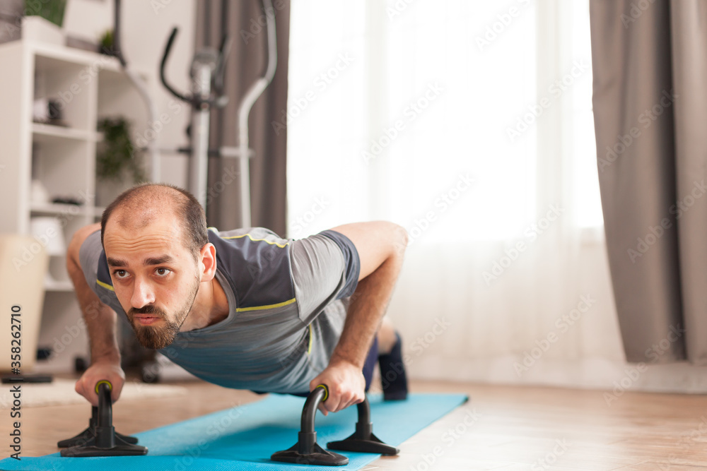 Athletic man doing push-up workout on yoga mat during covid-19 self isolation. Athletic man doing push-up workout on yoga mat during covid-19 self isolation.