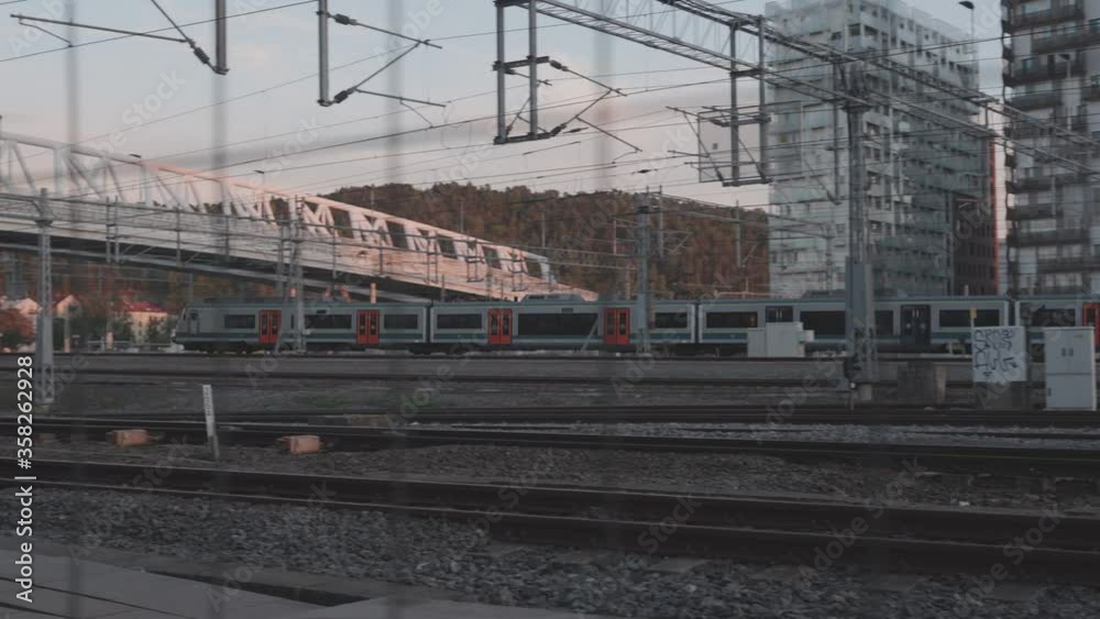 Slow motion tracking shot of train leaving Oslo central train station in sunset Slow motion tracking shot of train leaving Oslo central train station in sunset
