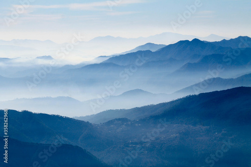 Fototapeta Naklejka Na Ścianę i Meble -  mountains in the fog. Misty mountain blue. Himalayan mountain range in uttrakhand Brahmatal. 