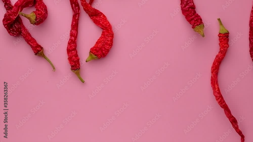 Slow motion of Red chili pepper falling down on the pink background or table. Concept spices of spicy food. Slow motion of Red chili pepper falling down on the pink background or table. Concept spices of spicy food.