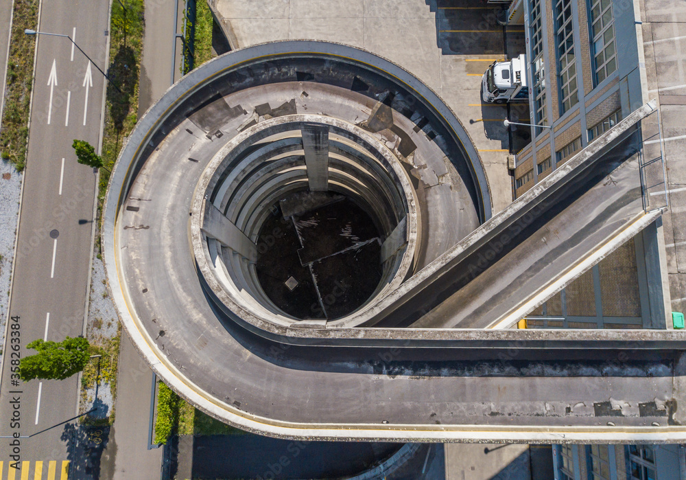 Aerial view of rooftop parking ramp. Spiral ramp leading cars to ...