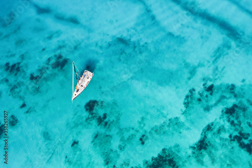 View from above, stunning aerial view of a sailing boat floating on a beautiful turquoise sea. Porto Cervo, Costa Smeralda, Sardinia, Italy.