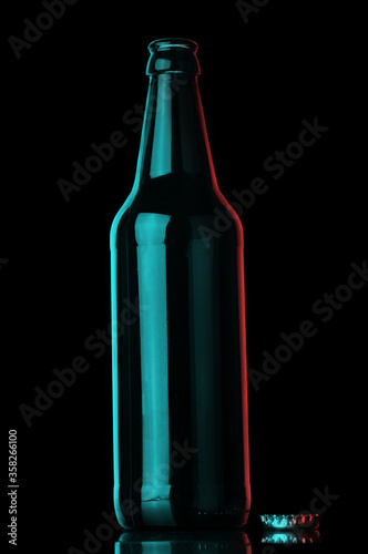 Empty beer bottle and cork on black background