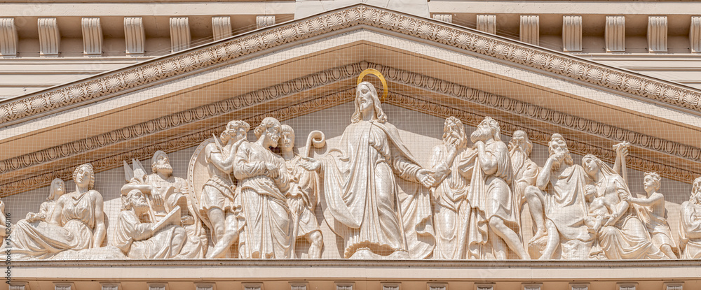 Fototapeta premium Panoramic view of bas relief sculptures of Biblical scene at the main portal of Evangelical church Saint Nikolai at blue sky, Potsdam, Germany