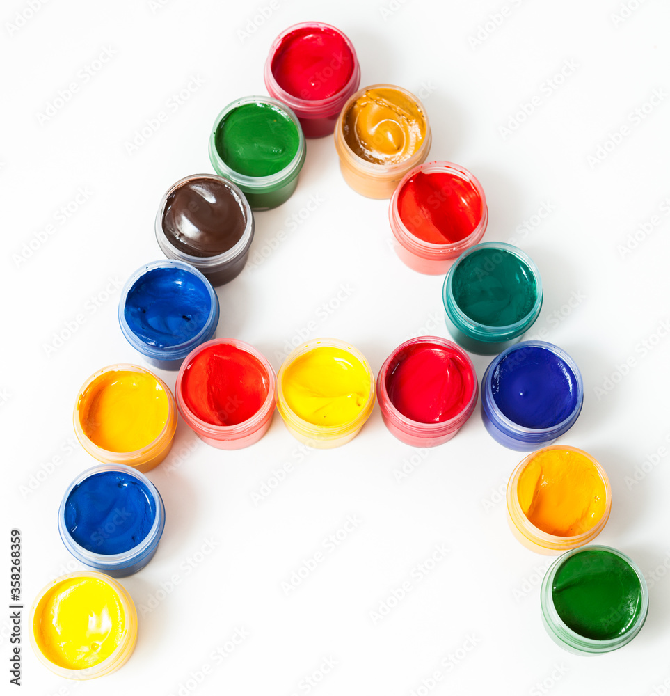 Colorful paints in plastic boxes in shape of A letter, white background Colorful paints in plastic boxes in shape of A letter, white background