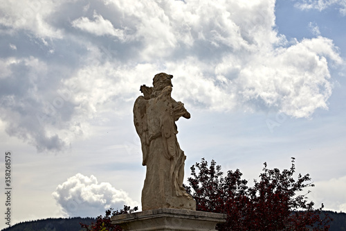 stone statue cloudy sky art saint