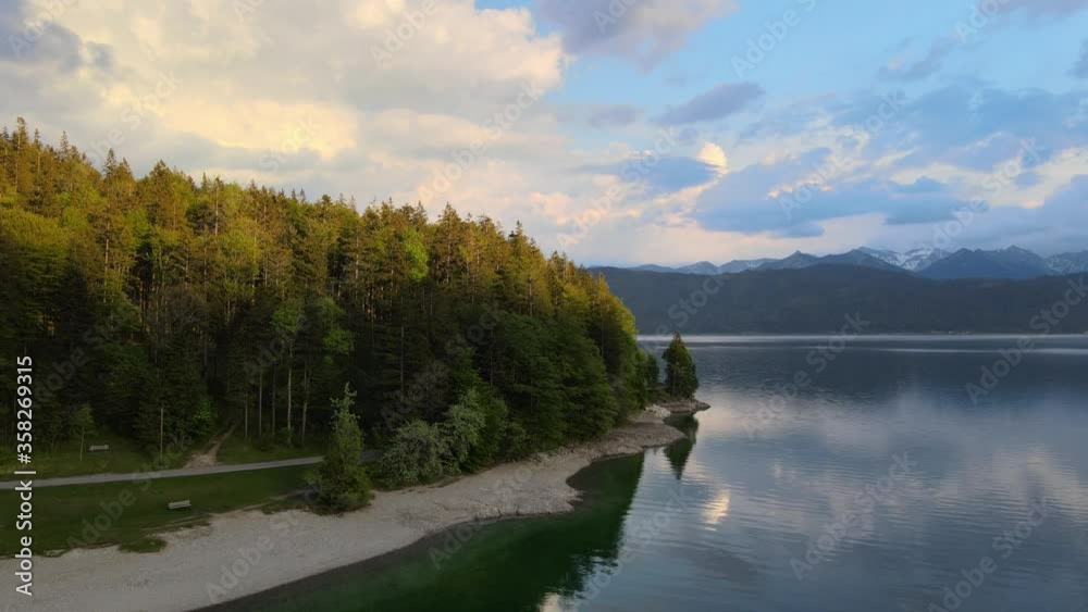 Aerial view revealing a woodland on the coast of lake Walchensee at sunset. Dolly out Aerial view revealing a woodland on the coast of lake Walchensee at sunset. Dolly out