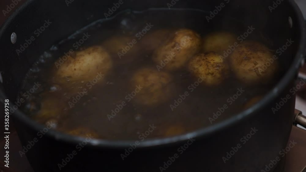 Close view of boiling potatoes in a saucepan. Cooking during camping. Close view of boiling potatoes in a saucepan. Cooking during camping.