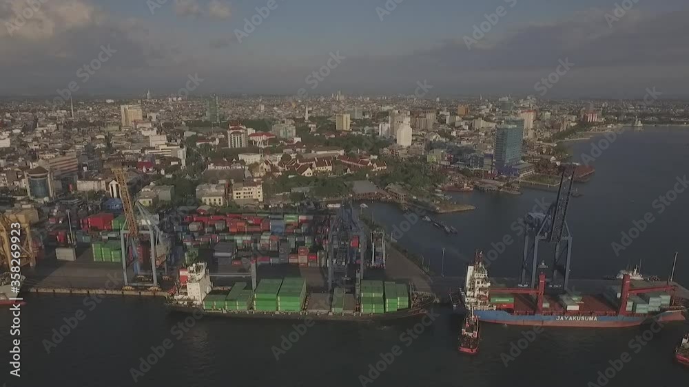 aerial view of container ships and cranes activities around the port of makassar, south sulawesi, indonesia aerial view of container ships and cranes activities around the port of makassar, south sulawesi, indonesia