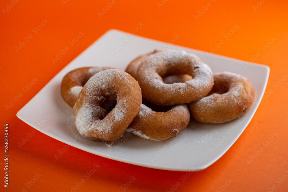 Yummy yellow dougnuts with granulated sugar.