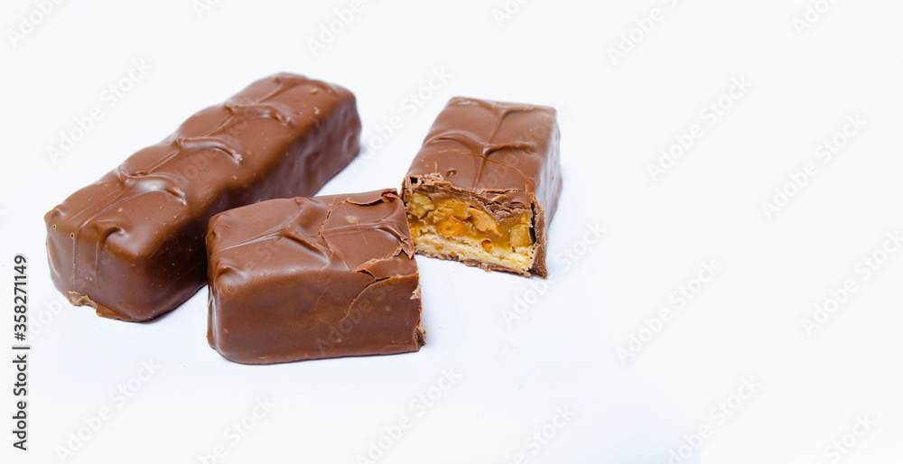 Two small snickers bars weighing 50 grams without packaging in macro are lying next to each other. Snickers one whole bar and another cut in half in macro. Chocolate cut in half close-up