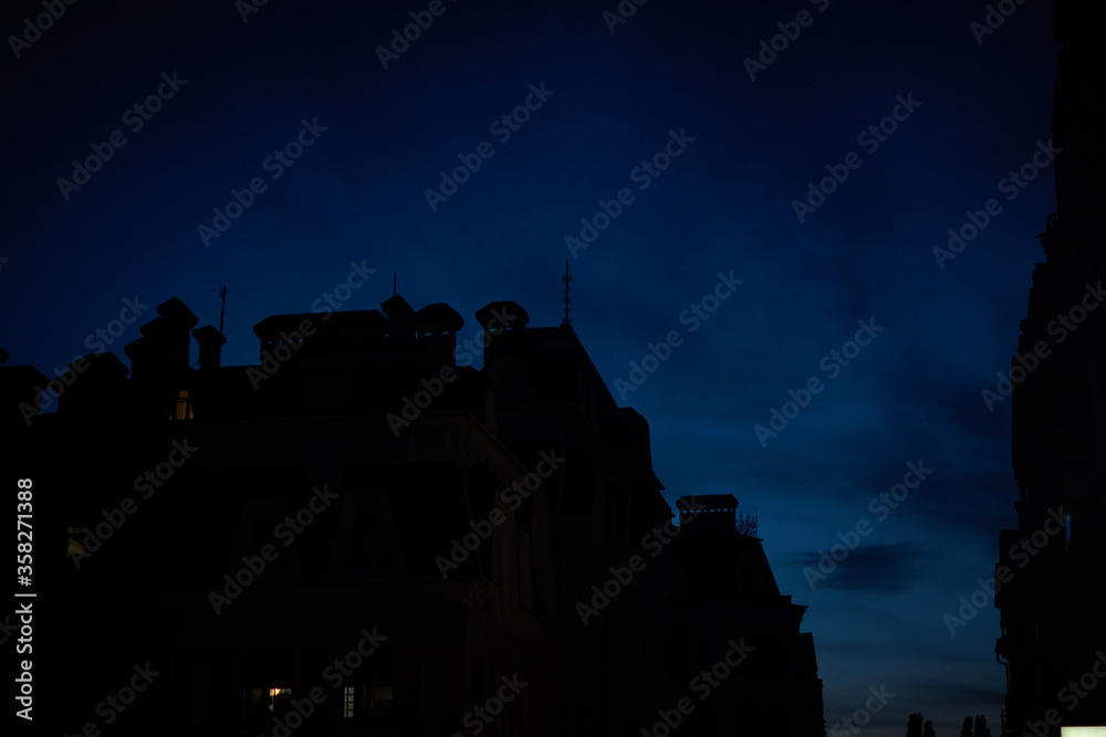 Obraz premium View of the night sky and the silhouettes of houses.