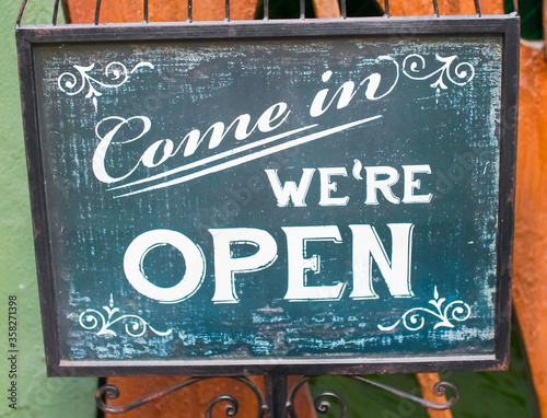Wallpaper Mural Metal sign saying "Come in we're open" in white letters on a green background Torontodigital.ca