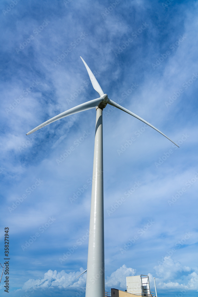 Close-up wind turbines or wind energy converter in sunny day with blue sky and white clouds Close-up wind turbines or wind energy converter in sunny day with blue sky and white clouds