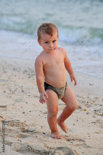cheerful boy on the beach with sea on background