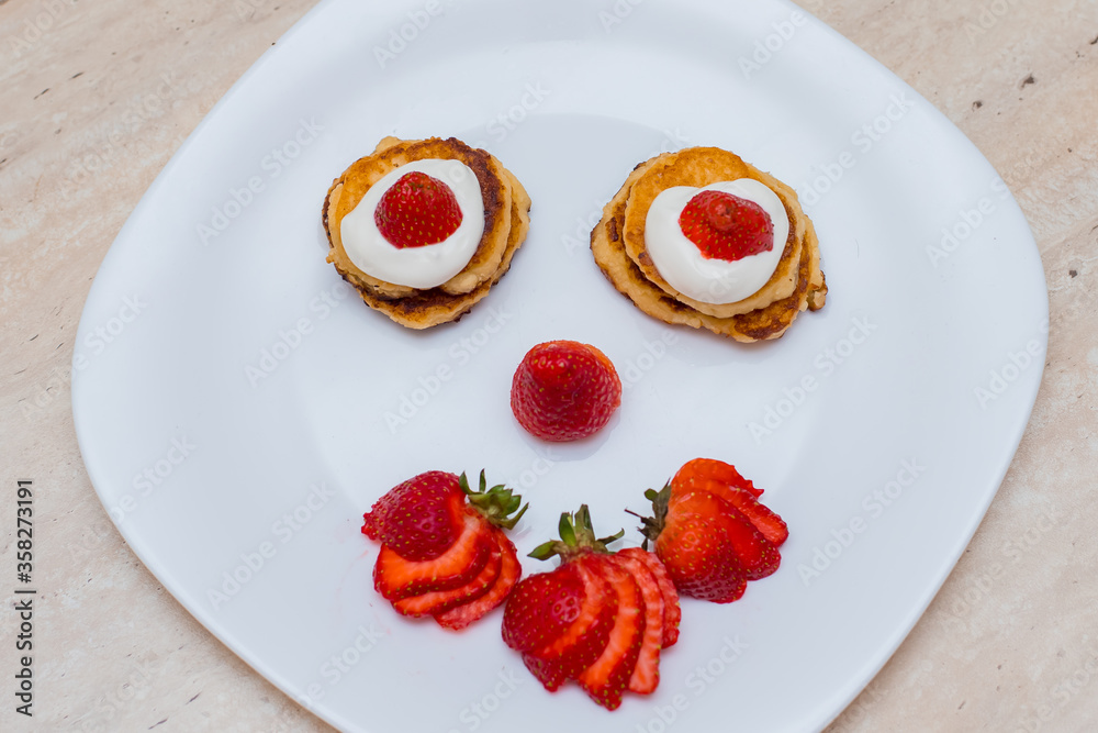 Delicious homemade pancakes with strawberries on plate on a light background Delicious homemade pancakes with strawberries on plate on a light background