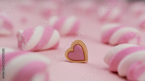 Lots of pink marshmallows on a pink background and heart between it. Valentine's day. High quality photo
