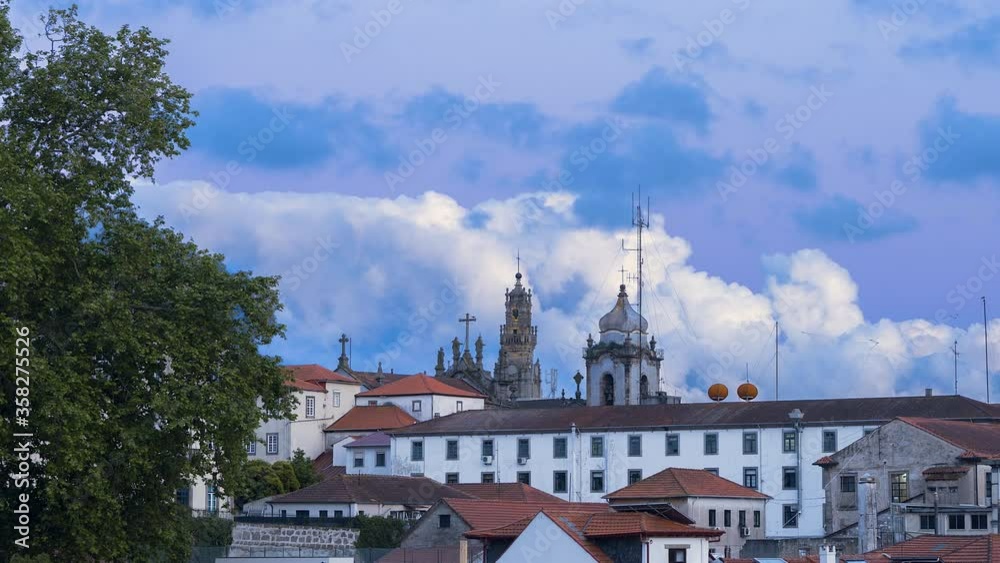 timelapse of old european buildings with tree on the left with beautiful clouds moving in the background during blue hour timelapse of old european buildings with tree on the left with beautiful clouds moving in the background during blue hour