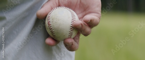 Canvas Print CU Adult man holding a baseball ball in his hands while playing catch with his s