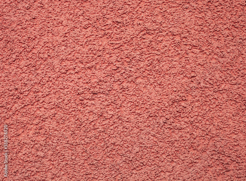 Texture pink pebble dash stucco on house facade
