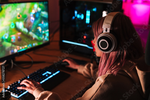 Fototapeta Image of caucasian focused girl playing video game on personal computer