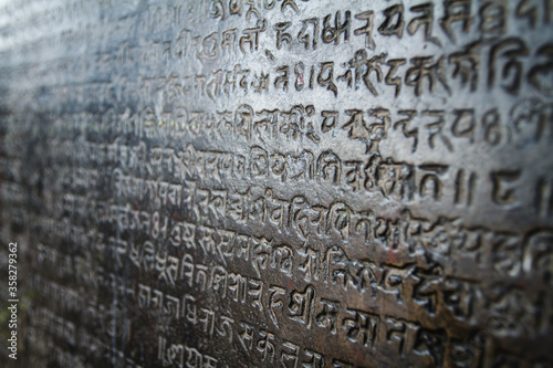 Nepali words writings carved on a stone wall