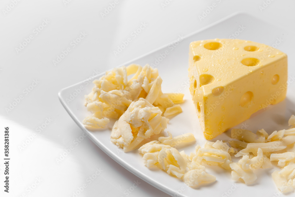 piece of Cheese and Cheddar Cheese grated on old vintage Cooking wooden table. Cheese background Texture and Copy space