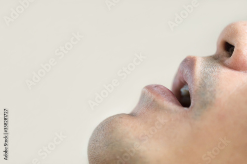 Asian young man is snoring loudly on the bed in the bedroom