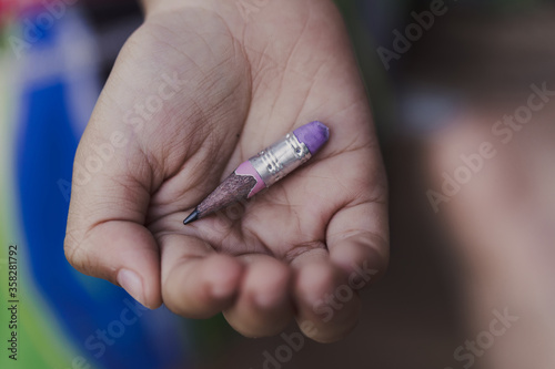 Short pencil on hand of an Asian little boy with poverty
