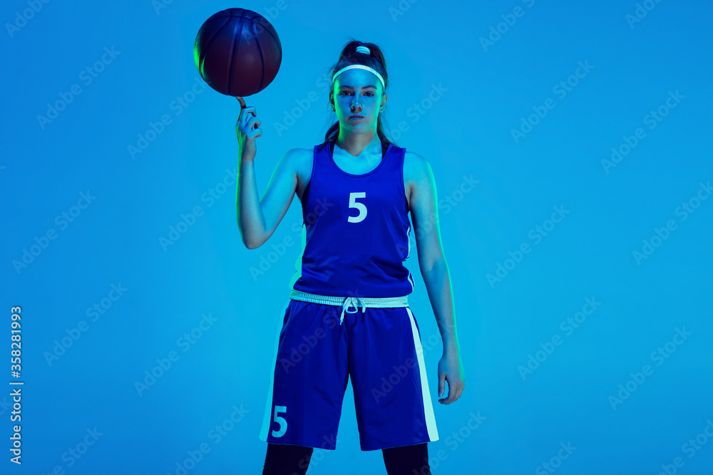 © master1305 - Young caucasian female basketball player of team posing confident with ball isolated on blue background in neon light. Concept of sport, movement, energy and dynamic, healthy lifestyle. Training. © master1305 - Young caucasian female basketball player of team posing confident with ball isolated on blue background in neon light. Concept of sport, movement, energy and dynamic, healthy lifestyle. Training.