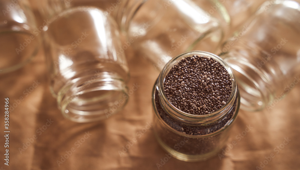 Glass jars. In one of which are the seeds of Chia. promotional photo Glass jars. In one of which are the seeds of Chia. promotional photo