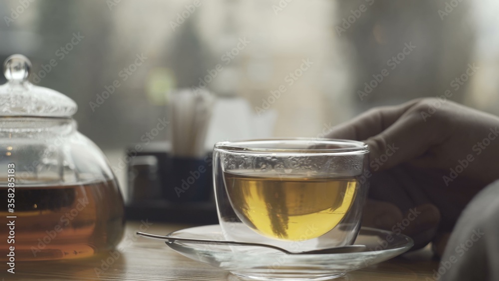 Teapot and cu with green tea on a table in cafe Teapot and cu with green tea on a table in cafe
