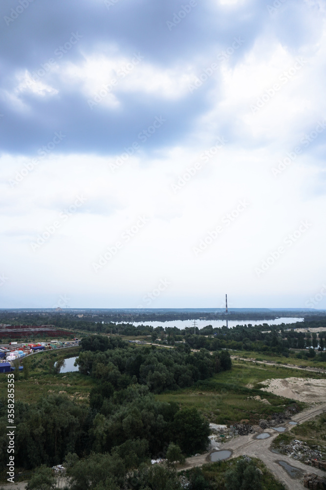Outskirts of the city industrial zone on the background of a river or lake. Stock photo for design