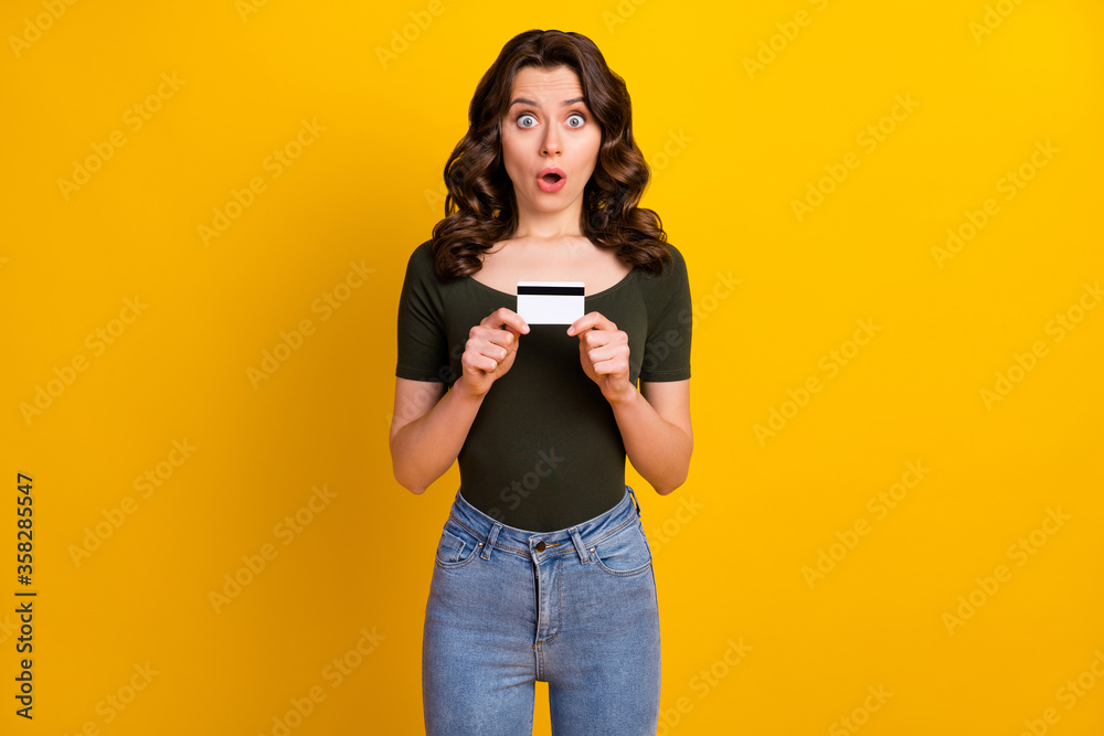 Portrait of her she nice attractive lovely pretty amazed cheerful cheery wavy-haired girl holding in hands bank card new cool service isolated on bright vivid shine vibrant yellow color background Portrait of her she nice attractive lovely pretty amazed cheerful cheery wavy-haired girl holding in hands bank card new cool service isolated on bright vivid shine vibrant yellow color background