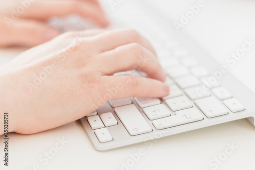 Close up, side view of Caucasian woman's hands typing on a keyboard. Business woman, selective focus